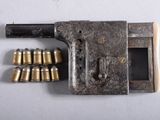 un vieux pistolet sur lequel sont posées plusieurs douilles