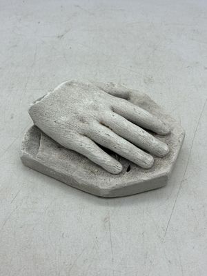 une sculpture représentant une main tenant un morceau de papier