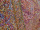 a close up of a colorful scarf hanging on a wall