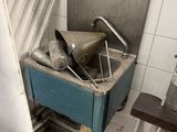 a blue box filled with silver items in a dirty bathroom