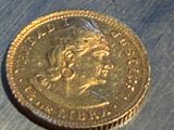 une pièce d'or posée sur une surface métallique