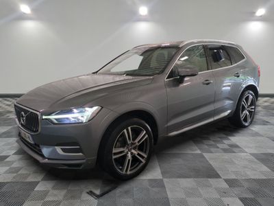 un SUV Volvo gris garé dans un garage au sol carrelé