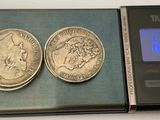 two coins sitting on top of a scale next to a clock