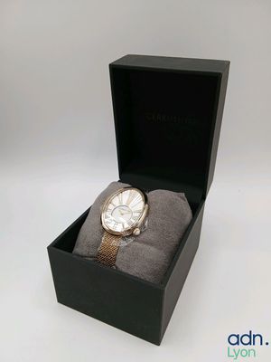 un gros plan d'une montre dans un coffret, sur fond blanc