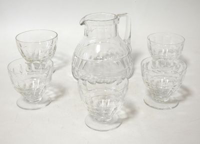 four glasses and a pitcher sitting on a table