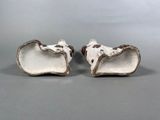 pair of white and brown ceramic animal figurines on grey background