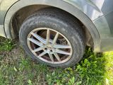 a car that is sitting in the grass with a tire on it