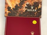 the rolex watch is in a red box with a gold crown on it