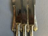 four knives and a knife holder on a table