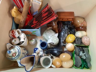 a box filled with assorted items that include tea cups, spoons, and other items