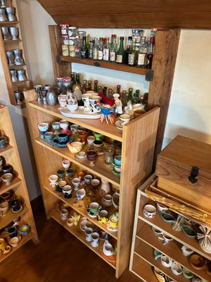 une étagère en bois remplie de tasses et de sauces dans une pièce