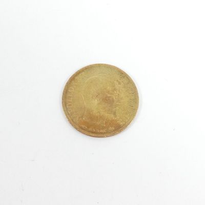 gros plan d'une pièce d'or sur une surface blanche