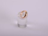 a close up of a ring with a gold band on top of a clear glass