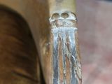 a close up of a wooden chair with a metal handle