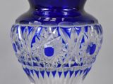 a blue glass vase with a flower design on it