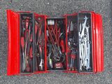 de nombreux outils dans une boîte rouge posée par terre