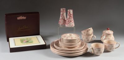 une table dressée avec des tasses, des soucoupes, des assiettes et une lampe