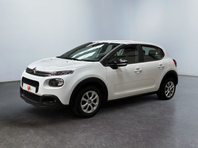 the small white car is parked in a room with a gray floor
