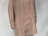 beige trench coat on a mannequin stand in front of a white backdrop