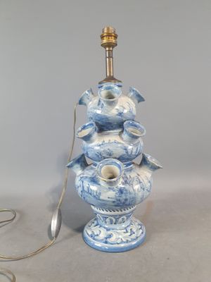 une lampe bleue et blanche surmontée d'un oiseau