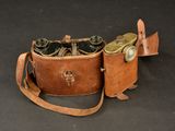 an old pair of binoculars sitting on top of a brown leather case