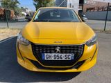 the front of a yellow car parked in a parking lot