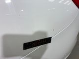 a close up of a white car with a sticker on it