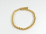 gros plan d'un bracelet en or sur fond blanc