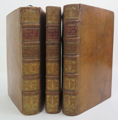 two old books sitting on top of each other on a white surface