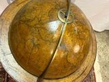 a small wooden globe on a rug on the floor