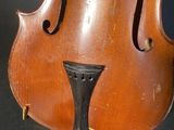an old violin being held up by a person ' s hand