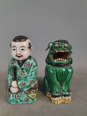 deux figurines asiatiques représentant un garçon et un chien sur un fond gris