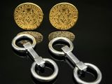 deux paires de boutons de manchette en or et en argent sur un fond noir
