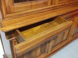 a large wooden cabinet with a drawer underneath it