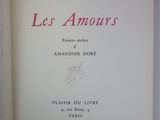 un livre ouvert posé sur une table à côté d'un mur blanc