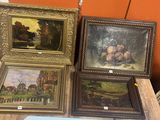 quatre tableaux encadrés posés sur une table dans une pièce