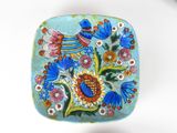 a blue plate with a bird and flowers design on it