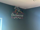 une enseigne lumineuse portant l'inscription « Budweiser » sur le mur d'une pièce