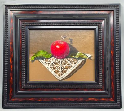 tableau représentant une pomme dans un panier en osier, sur laquelle repose une feuille