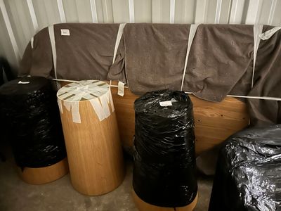 many bags of garbage sitting on the floor next to a couch