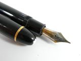 two fountain pens sitting next to each other on a table
