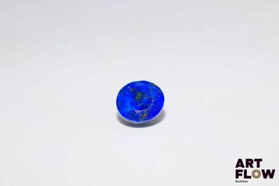 a close up of a blue stone on a white surface
