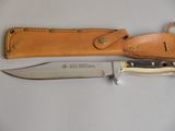 un couteau posé sur une table à côté d'un étui en cuir