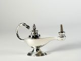 une lampe à huile ancienne en argent sur fond blanc