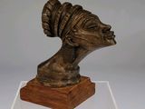 bronze bust of a woman with a turban on a wooden base