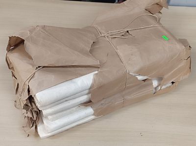 a brown paper bag that has a bunch of folded towels on it