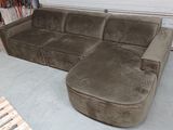 a couch and ottoman in a garage with pallets on the floor
