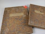 Voici deux vieux livres posés sur une table blanche