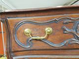 a wooden dresser with a brass handle on it
