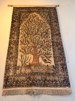 an old tapestry hanging on a wall with a tree and birds
